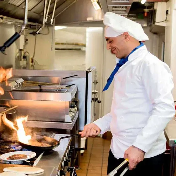 Ashton Gardens Chef Created Meals, chef frying a dish.