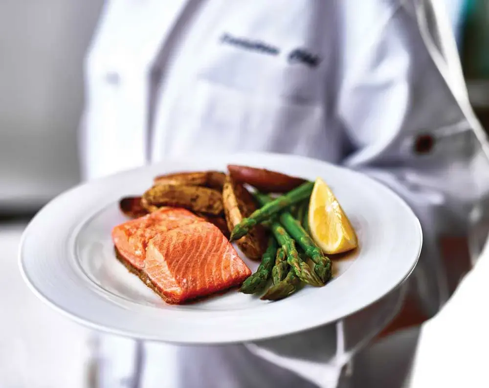 Ashton Gardens Chef Created Meals, chef delivering a finished dish.