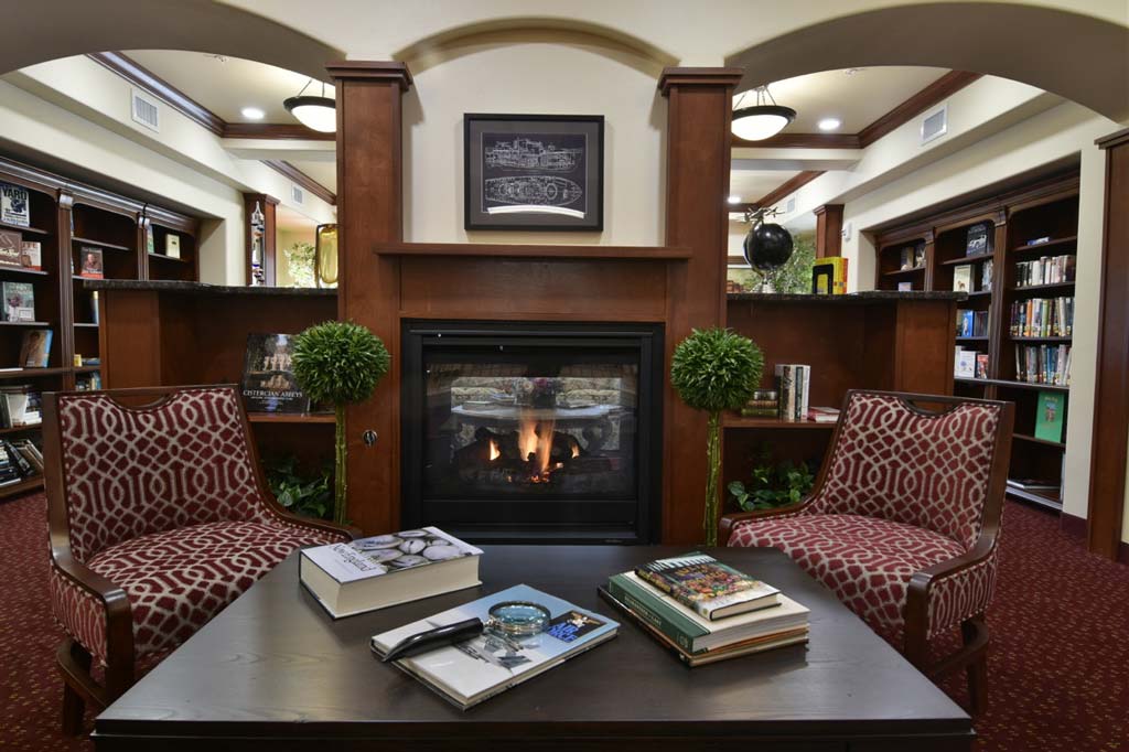 The library at Ashton Gardens with shelves of books and comfortable seating